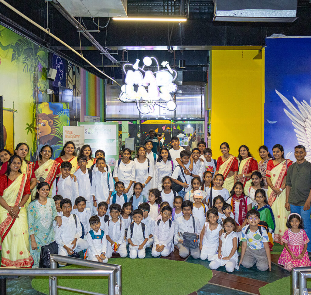 School group visiting MAD Labs Bangalore for an experiential field trip, posing with teachers at the entrance inside Snow City.