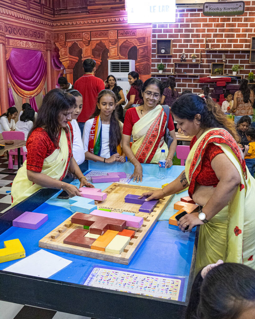 Teachers and students enjoying teamwork challenge at Puzzle Lab in MAD Labs
