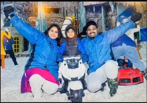 Family enjoying Snow Park at Snow City Bangalore, posing together on a snow bike in the winter-themed indoor play zone.